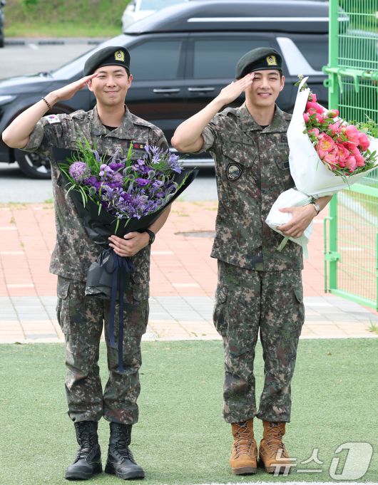 방탄소년단(BTS)의 RM(김남준, 30)과 뷔(김태형, 29)가 10일 오전 강원도 춘천시 신북읍 체육공원 축구장에서 군 복무를 마친 뒤 전역 인사를 하고 있다. ⓒ News1 권현진 기자