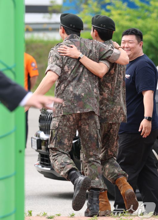 방탄소년단(BTS)의 RM(김남준, 30)과 뷔(김태형, 29)가 10일 오전 강원도 춘천시 신북읍 체육공원 축구장에서 전역 인사를 마친 뒤 어깨 동무를 하고 준비된 차량으로 이동하고 있다. ⓒ News1 권현진 기자