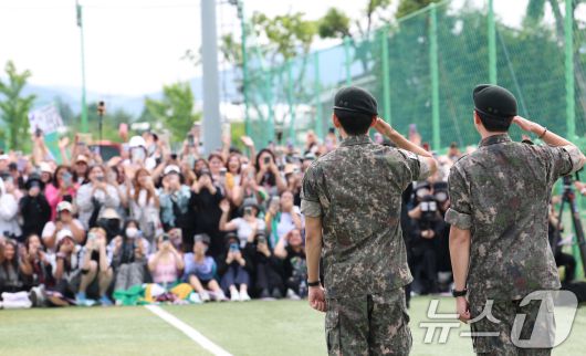방탄소년단(BTS)의 RM(김남준, 30)과 뷔(김태형, 29)가 10일 오전 강원도 춘천시 신북읍 체육공원 축구장에서 군 복무를 마친 뒤 전역 인사를 하고 있다. ⓒ News1 권현진 기자