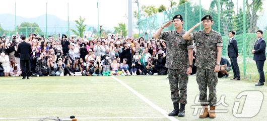 방탄소년단(BTS)의 RM(김남준, 30)과 뷔(김태형, 29)가 10일 오전 강원도 춘천시 신북읍 체육공원 축구장에서 군 복무를 마친 뒤 씩씩한 전역 인사를 하고 있다. ⓒ News1 권현진 기자