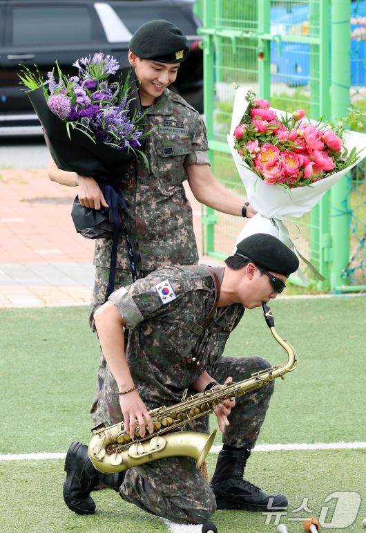 방탄소년단(BTS)의 RM(김남준, 30)과 뷔(김태형, 29)가 10일 오전 강원도 춘천시 신북읍 체육공원 축구장에서 군 복무를 마친 뒤 전역 인사를 하고 있다. 2025.6.10/뉴스1 ⓒ News1 권현진 기자