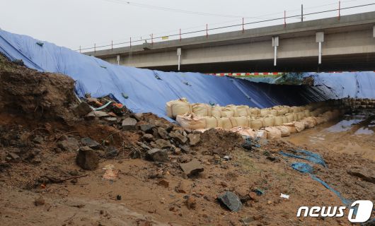 14명의 사망자가 발생한 오송 지하차도 참사의 시작이 된 미호천교 재가설 공사 현장. 참사 사흘이 지난 18일 충북 청주시 오송읍 궁평지하차도 인근 미호강 임시 제방에 방수포와 함께 모래주머니가 둘러져 있다. 2023.7.18/뉴스1 ⓒ News1 구윤성 기자