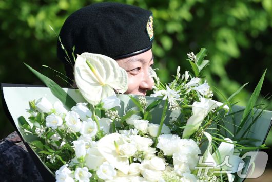 방탄소년단(BTS)의 정국이 11일 오전 경기도 연천군 연천공설운동장에서 군 복무를 마친 뒤 꽃다발을 받고 수줍은 미소를 짓고 있다. 정국과 지민은 지난 2023년 12월 입대해 경기도 연천에 위치한 육군 제5보병사단에서 약 1년 7개월간 병역의 의무를 성실히 수행했다. 2025.6.11/뉴스1 ⓒ News1 권현진 기자