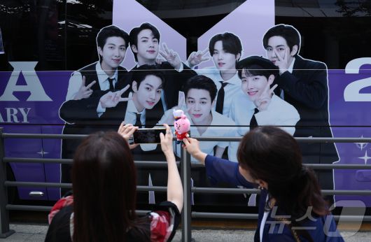9일 오전 서울 용산구 하이브 사옥 앞에서 방탄소년단(BTS) 글로벌 팬들(아미)이 멤버들의 제대를 기대하며 기념 촬영을 하고 있다. 2023년 12월 입대한 그룹 방탄소년단(BTS)의 RM, 뷔, 지민, 정국이 이번 주 육군 현역 복무를 마치고 만기 전역한다. 2025.6.9/뉴스1 ⓒ News1 권현진 기자