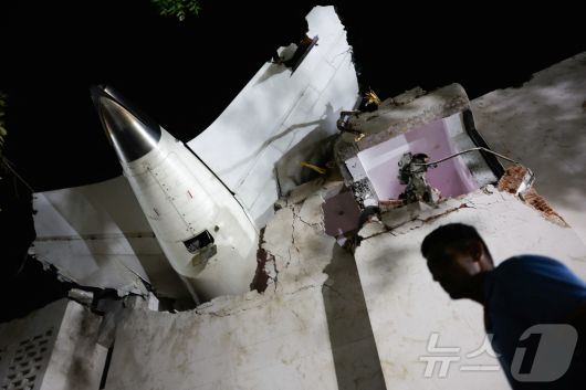 인도 에어인디아 소속 보잉 787드림라이너 여객기가 12일(현지시간) 인도 서부 아메다바드 공항 인근에서 추락했다. 사진은 추락한 건물 꼭대기에 기체 꼬리가 박힌 모습. 2025.06.12 ⓒ 로이터=뉴스1 ⓒ News1 최종일 선임기자