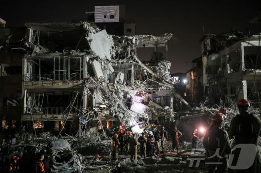 13일(현지시간) 이란의 미사일 반격으로 파괴된 이스라엘 라맛간의 건물 잔해에서 요원들이 구조 작업 활동을 벌이고 있다. 2025.06.13 ⓒ 로이터=뉴스1 ⓒ News1 류정민 특파원