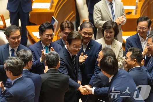 이재명 대통령이 26일 국회 본회의장에서 2025년도 제2회 추가경정예산안에 대한 정부의 시정연설을 하기 위해 본회의장으로 입장하며 더불어민주당 의원들과 인사를 나누고 있다. 2025.6.26/뉴스1 ⓒ News1 국회사진기자단