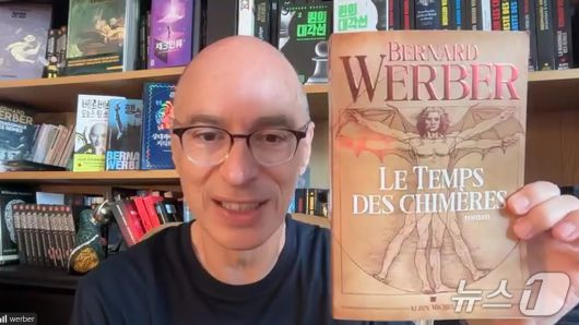 베르나르 베르베르가 1일 오후 열린 온라인 기자간담회 중 신작 소설 '키메라의 땅'을 들어보이고 있다.