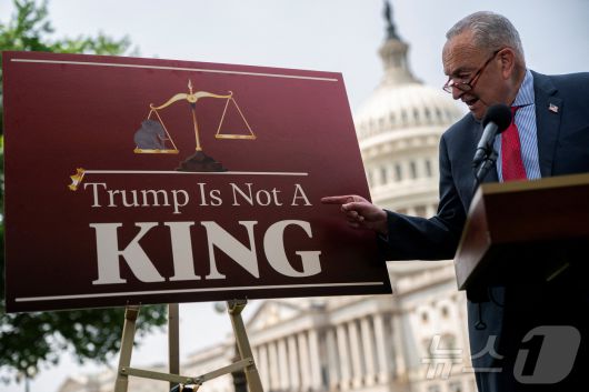 척 슈머 미국 민주당 상원 원내대표가 5일(현지시간) 워싱턴 국회의사당에서 도널드 트럼프 대통령의 감세안 관련 기자회견을 하는 도중에 '트럼프는 왕이 아니다'라고 적힌 패널을 손가락으로 가리키고 있다. 2025.06.05 ⓒ 로이터=뉴스1 ⓒ News1 최종일 선임기자