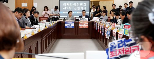 3일 세종시 정부세종청사 고용노동부에서 열린 최저임금위원회 제9차 전원회의에 참석한 노사 위원들이 양측의 주장이 담긴 손팻말을 게시하고 회의를 진행하고 있다. 2025.7.3/뉴스1 ⓒ News1 김기남 기자