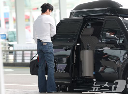 방탄소년단(BTS) 뷔(본명 김태형)가 해외 일정을 위해 4일 오전 인천국제공항에 도착해 차에서 내린 뒤 매무새를 고치고 있다. ⓒ News1 권현진 기자