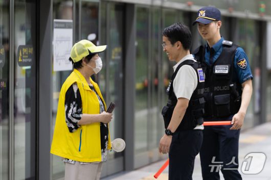 신창훈 지하철경찰대 안전계장이 2일 서울 성동구 왕십리역 승강장을 순찰하다 장애인 안내도우미와 대화하고 있다. 2025.7.2  ⓒ 뉴스1 이승배 기자