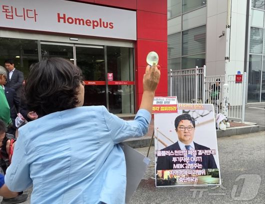 마트 노동자들이 2일 천안시 동남구 홈플러스 천안점 앞에서 열린 폐점 반대 기자회견에서 김병주 MBK파트너스 회장을 규탄하며 얼굴 사진에 물풍선을 던지고 있다. 2025.6.2/뉴스1 ⓒ News1 이시우 기자