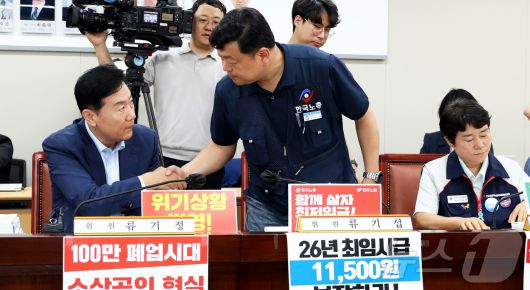 8일 세종시 정부세종청사 고용노동부에서 열린 최저임금위원회 제10차 전원회의에서 류기섭 사용자위원과 류기정 근로자위원이 회의에 참석하며 악수하고 있다. 2025.7.8/뉴스1 ⓒ News1 김기남 기자