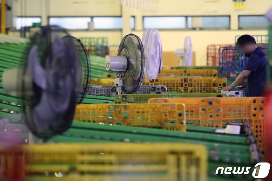 연일 폭염이 이어지고 있는 1일 오전 서울 광진구 동서울우편물류센터에서 택배 노동자가 선풍기 바람을 맞으며 분류 작업을 하고 있다. 2023.8.1/뉴스1 ⓒ News1 황기선 기자