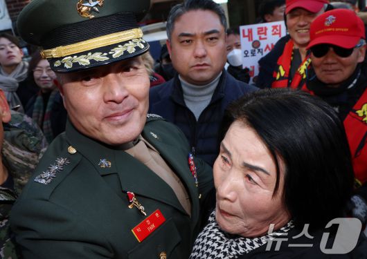 채 상병 순직 사건과 관련해 항명 및 상관명예훼손 혐의로 기소된 박정훈 전 해병대 수사단장(대령)이 지난 1월 9일 오전 서울 용산구 중앙지역군사법원에서 열린 1심 선고공판을 마치고 나와 어머니와 포옹을하고 있다.  2025.1.9/뉴스1 ⓒ News1 김명섭 기자