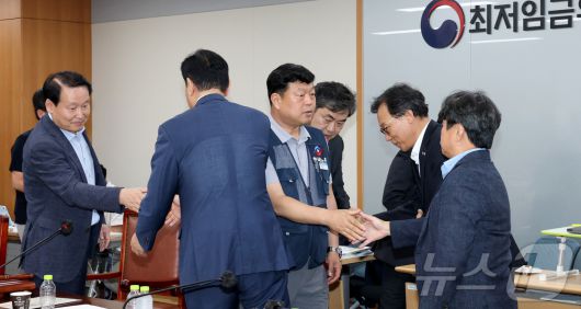 10일 저녁 세종시 정부세종청사 고용노동부에서 열린 최저임금위원회 제12차 전원회의에서 사용자위원과 한국노총 근로자위원들만이 참여하여 2026년 최저임금을 10,320원으로 합의하며 류기정 사용자위원과 류기섭 근로자위원 등이 회의장을 떠나며 인사를 나누고 있다. 2025.7.10/뉴스1 ⓒ News1 김기남 기자