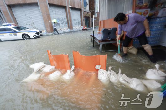 호우경보가 발효된 17일 광주 남구 백운동 일대의 상가가 침수돼 주인이 가게앞 빗물을 쓸어내고 있다. 2025.7.17/뉴스1 ⓒ News1 김태성 기자