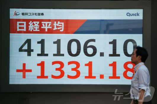 23일 일본 도쿄 증권거래소의 닛케이 평균 주가를 표시하는 전광판 앞을 한 남성이 지나가고 있다. 도쿄 증시는 이날 일본과 미국이 도널드 트럼프 대통령이 부과한 관세를 대폭 인하하는 무역 협정을 마무리 지으면서 급등했다.2025.07.23. ⓒ AFP=뉴스1 ⓒ News1 권영미 기자