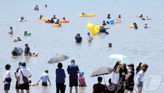 전국 대부분 지역에 폭염특보가 내려진 27일 오후 인천 중구 을왕리 해수욕장을 찾은 시민들이 더위를 식히고 있다. 2025.7.27/뉴스1 ⓒ News1 김진환 기자