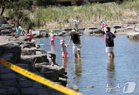 폭염경보가 내려진 27일 광주 동구 용산동 광주천 물놀이장에 서 시민들이 '운영 잠정 취소' 통제선을 넘어 여전히 하천에서 물놀이를 즐기고 있다. 2025.7.27/뉴스1 ⓒ News1 박지현 기자
