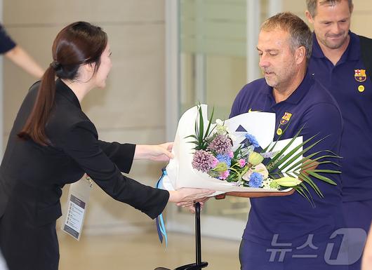 FC 바르셀로나의 한지 플릭 감독을 비롯한 코칭 스테프가 29일 오후 인천국제공항 2터미널을 통해 입국하며 관계자에게 꽃다발을 받고 있다. 2025.7.29/뉴스1 ⓒ News1 김진환 기자