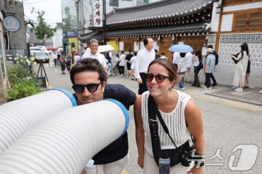 절기상 중복인 30일 서울 종로구의 한 삼계탕집 앞에서 더위에 지친 외국인 관광객이 냉풍기 바람으로 더위를 식히고 있다. 2025.7.30/뉴스1 ⓒ News1 박지혜 기자