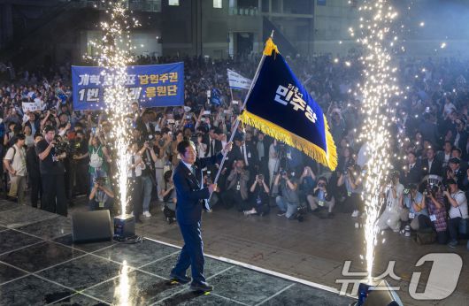 정청래 더불어민주당 신임 당대표가 2일 경기 고양시 킨텍스에서 열린 제2차 임시전국당원대회에서 당기를 흔들고 있다. (공동취재) 2025.8.2/뉴스1 ⓒ News1 유승관 기자