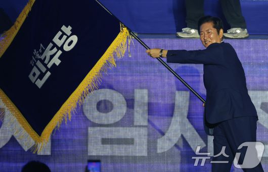 정청래 더불어민주당 신임 당대표가 2일 경기 고양시 킨텍스에서 열린 제2차 임시전국당원대회에서 당기를 흔들고 있다. (공동취재) 2025.8.2/뉴스1 ⓒ News1 유승관 기자