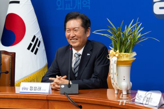 정청래 더불어민주당 신임 대표가 4일 오후 서울 여의도 국회에서 우상호 대통령실 정무수석으로부터 대통령 축하 난을 받고 미소 짓고 있다. 2025.8.4/뉴스1 ⓒ News1 이승배 기자