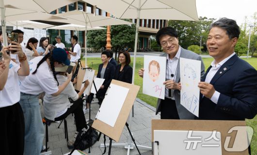 박주민 국회 보건복지위원장이 27일 서울 여의도 국회 소통관 앞에서 열린 '문신사법 의결 경축' 타투이스트들의 캐리커처 행사에 참석해 캐리커처를 들고 있다. 2025.8.27/뉴스1 ⓒ News1 이승배 기자