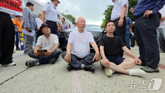 김형석 관장의 사퇴를 촉구하며 관장실을 점거 농성 중인 오주현 씨(오른쪽)가 지난 25일 김형석 관장의 출근을 저지하기 위해 차량을 막아서고 있다. 2025.8.25./뉴스1ⓒNews1 이시우 기자