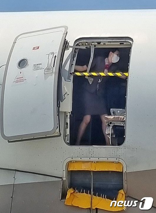 2023년 5월 26일 제주에서 출발해 대구로 향하던 아시아나항공기에 탑승한 30대 남성 A씨가 대구공항 상공에서 비상문을 강제로 개방해 승객들을 공포에 떨게 한 가운데 승무원이 비상문을 온몸으로 막고 있다.(독자 제공) 2023.5.28/뉴스1 ⓒ News1 공정식 기자