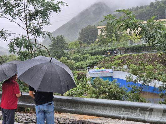 20일 오후 강릉 성산면 오봉리 한국수력원자력 강릉수력발전소에서 예정된 도암댐 도수관로 저류수 방류를 보기 위한 주민과 시 관계자들이 우산을 쓰고 현장을 바라보고 있다. 2025.9.20/뉴스1 ⓒ News1 윤왕근 기자