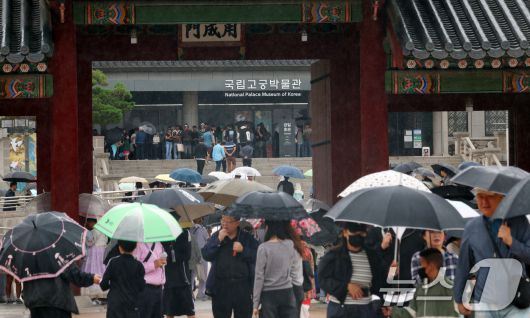 추석인 6일 서울 종로구 경복궁에서 비가 내리는 가운데 시민들과 외국인 관광객들이 나들이를 하고 있다. 추석 연휴 기간동안 경복궁, 창덕궁, 덕수궁, 창경궁 등 4대 궁과 종묘, 조선왕릉이 무료로 개방되어 누구나 자유롭게 관람할 수 있다. 2025.10.6/뉴스1 ⓒ News1 김명섭 기자