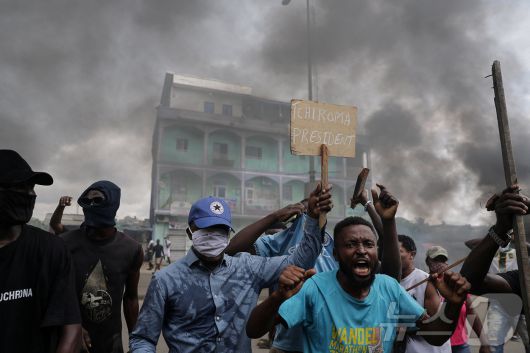 27일(현지시간) 카메룬 헌법위원회가 폴 비야 대통령의 승리를 선언한 뒤, 카메룬 두알라에서 야권 후보인 이사 치로마 바카리의 지지자들이 보안군과 충돌하는 가운데 한 남성이 '치로마 대통령'이라고 쓰인 피켓을 들고 있다. 2025.10.27. ⓒ 로이터=뉴스1 ⓒ News1 윤다정 기자