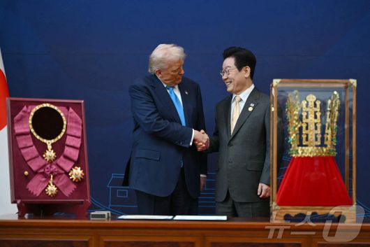 이재명 대통령이 29일 경북 경주박물관에서 열린 한미 공식 환영식에서 도널드 트럼프 미국 대통령에게 무궁화 대훈장 수여와 천마총 금관 모형을 선물한 뒤 악수하고 있다. ⓒ AFP=뉴스1