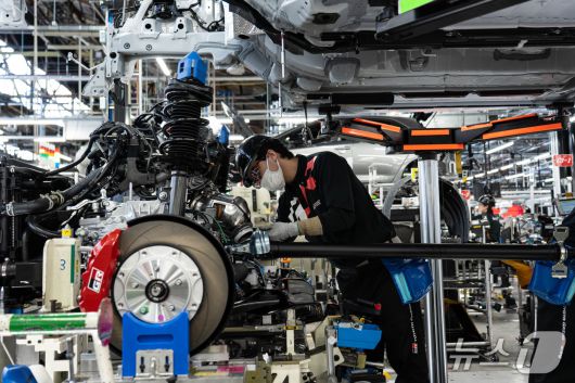 31일 일본 아이치현 소재 도요타 GR 공장에서 작업자가 차체 하부의 구동·조향 장치를 조립하고 있다. 무인운반차(AGV)에 실린 차체는 하단에 고정된 차체 하부로 내려와 연결됐다(한국토요타자동차 제공). 2025.10.31.