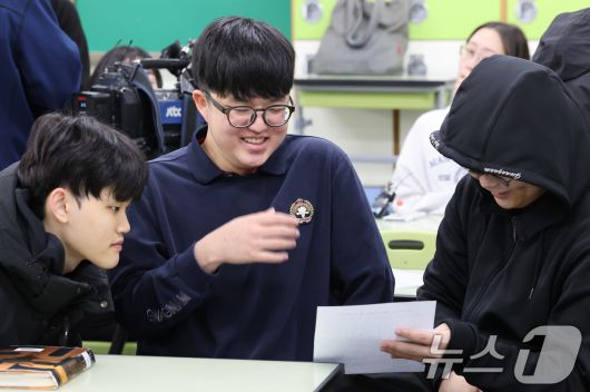 2025학년도 대학수학능력시험 성적표가 배부된 5일 오전 서울 광진구 광남고등학교에서 '수능 만점자' 왕정건 학생이 성적표를 확인하며 친구들의 축하를 받고 있다. (공동취재) ⓒ News1 오대일 기자