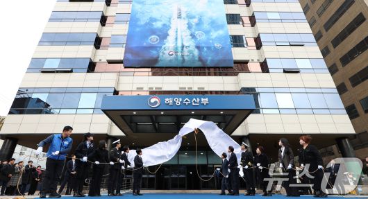 이재명 대통령이 23일 부산 동구 해양수산부 청사에서 열린 개청식에서 제막식을 하고 있다. 오른쪽부터 해수부 이석민 주무관 모친 정성미 씨, 박은혜 해수부 주무관, 이희숙 원조콩나물비빔밥 사장, 이대규 SK해운 선장, 박형준 부산시장, 김성범 해수부 장관 직무대행, 이재명 대통령, 김민석 총리, 구본민 한국해양대학교 학생, 박혜라 씨드(SEA.D) 대표, 윤경희 에이치라인해운 2등 항해사, 윤병철 해수부 주무관. (대통령실통신사진기자단) 2025.12.23/뉴스1 ⓒ News1 이재명 기자