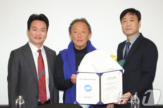 지휘자 정명훈(가운데)이 26일 서울 영등포구 콘래드호텔에서 열린 ‘KBS교향악단 창단 70주년& KBS교향악단 10대 음악감독 선임' 기자회견에 참석해 임명장을 받은 뒤 박장범 KBS 사장(왼쪽)과 이승환 KBS교향악단 사장(오른쪽)과 함께 기념 촬영을 하고 있다. 2025.12.26/뉴스1 ⓒ News1 권현진 기자