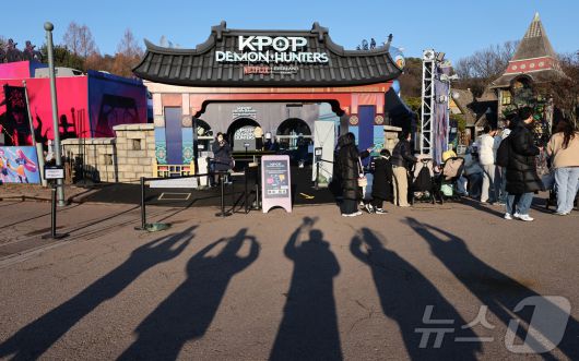 경기 용인시 에버랜드 내 케이팝 데몬 헌터스 팝업존을 찾은 관람객들이 갓 모자를 든 모습의 그림자를 만들고 있다. ⓒ News1 장수영 기자