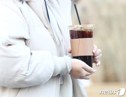 서울 종로구 광화문네거리에서 시민이 커피를 들고 발걸음을 옮기고 있다.ⓒ News1 김민지 기자