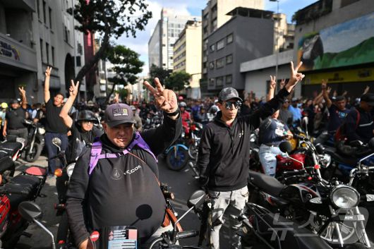 니콜라스 마두로 베네수엘라 대통령이 체포된 다음 날인 4일(현지시간) 베네수엘라 카라카스에서 마두로 지지자들이 오토바이를 타고 'V'자 손짓을 하고 있다. 2026.01.04. ⓒ AFP=뉴스1 ⓒ News1 이정환 기자