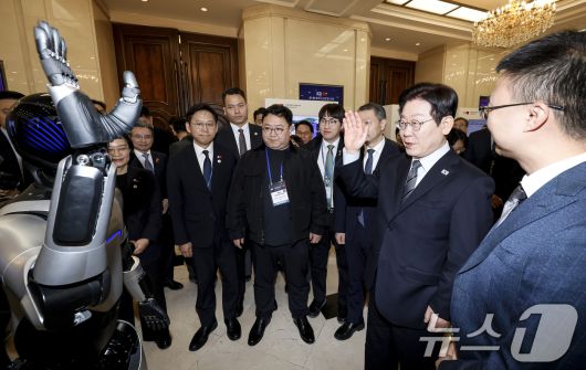 이재명 대통령이 7일 중국 상하이 국제회의중심에서 열린 한중 벤처스타트업 서밋 행사에서 중국 기업 엣지봇의 휴머노이드 로봇을 살펴보고 있다. 2026.1.7/뉴스1 ⓒ News1 허경 기자
