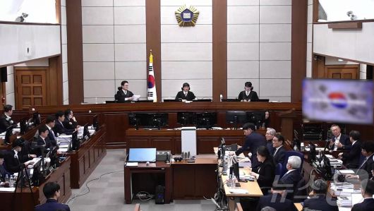 윤석열 전 대통령이 13일 오후 서울 서초구 서울중앙지방법원에서 진행된 내란 우두머리 혐의 2차 결심공판에 출석해 자리에 앉아 윤갑급 변호사와 대화를 하고 있다. (서울중앙지방법원 제공 영상 캡쳐. 재판매 및 DB 금지) 2026.1.13/뉴스1