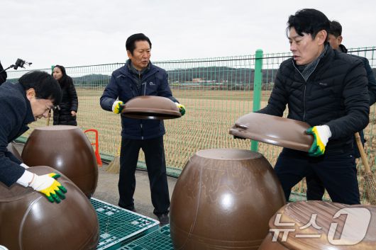 정청래 더불어민주당 대표가 14일 충남 당진시 백석올미마을기업을 방문해 장독 옮기기 작업을 하고 있다. 오른쪽은 한민수 당대표 비서실장. 2026.1.14/뉴스1 ⓒ News1 유승관 기자
