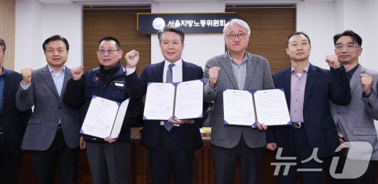 14일 서울 영등포구 서울지방노동위원회에서 열린 특별조정위원회 2차 사후 조정회의에서 서울 시내버스 노사가 임금협상에 극적으로 합의한 뒤 박점곤 서울시버스노동조합 위원장과 김정환 서울시버스사업조합 이사장을 비롯한 참석자들이 기념 촬영을 하고 있다. 2026.1.15/뉴스1 ⓒ News1 박지혜 기자