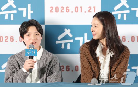 배우 최지우(오른쪽)가 15일 서울 광진구 롯데시네마에서 열린 영화 ‘슈가'(감독 최신춘) 언론시사회에서 극 중 아들로 출연하는 고동하 배우를 바라보며 미소짓고 있다. '슈가'는 모성애를 넘어선 사회적 편견의 극복, 가족의 연대와 사랑을 유쾌하고 따뜻한 시선으로 그린 웰메이드 휴먼 드라마다. 2026.1.15/뉴스1 ⓒ News1 권현진 기자