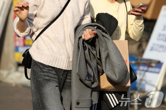 하루 사이 기온이 크게 오른 15일 오후 대구 중구 동성로에서 외투를 벗어 손에 든 시민들이 걸어가고 있다. 2026.1.15/뉴스1 ⓒ News1 공정식 기자